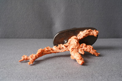 A Chinese carved red coral group of a lady among blossoming branches, 19th C.