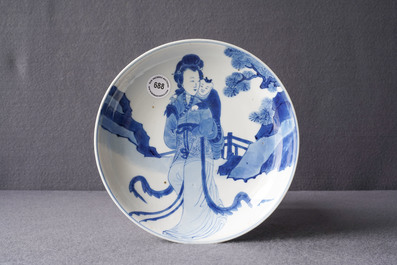 A Chinese blue and white semi-eggshell plate with a lady carrying a child, Kangxi