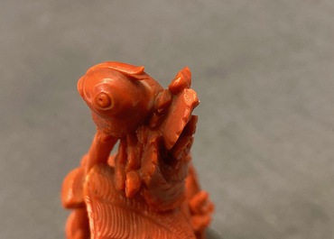 A Chinese carved red coral group of a boy with a parrot, 19/20th C.