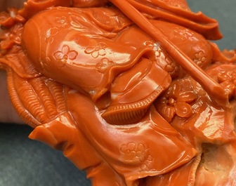 A Chinese carved red coral group of a boy with a parrot, 19/20th C.