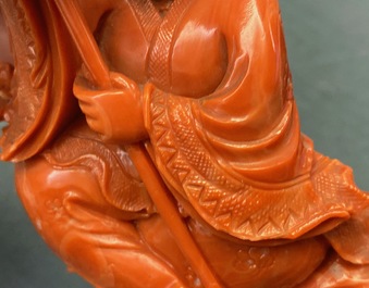 A Chinese carved red coral group of a boy with a parrot, 19/20th C.