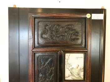 A Chinese wooden closet with 23 qianjiang cai plaques, 19/20th C.