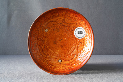 Une assiette en gr&egrave;s porcelaineux &agrave; couverte ambre &agrave; d&eacute;cor en relief, Liao (916-1125)