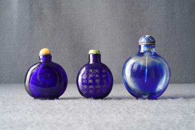 Three Chinese transparent blue glass snuff bottles, one inscribed, 18/19th C.
