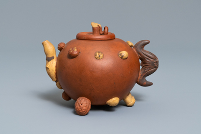 A Chinese Yixing stoneware relief-decorated teapot with nuts and fruits, impressed mark, 19th C.