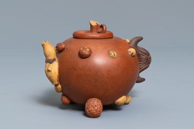 A Chinese Yixing stoneware relief-decorated teapot with nuts and fruits, impressed mark, 19th C.