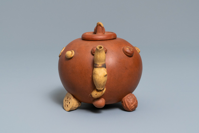 A Chinese Yixing stoneware relief-decorated teapot with nuts and fruits, impressed mark, 19th C.