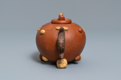 A Chinese Yixing stoneware relief-decorated teapot with nuts and fruits, impressed mark, 19th C.