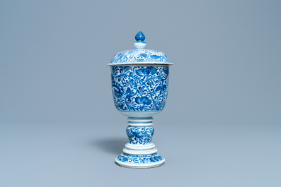 Een Chinese blauw-witte dekselbeker met floraal decor, Kangxi