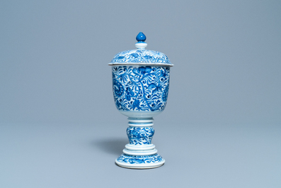 Een Chinese blauw-witte dekselbeker met floraal decor, Kangxi