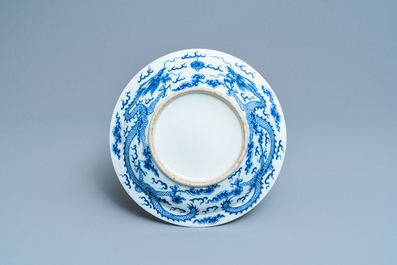 A Chinese blue and white 'dragon' dish and a famille rose figure of Buddha, 19th C.