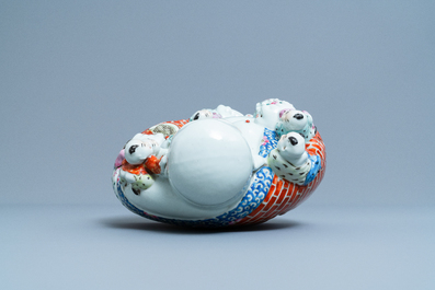 A Chinese blue and white 'dragon' dish and a famille rose figure of Buddha, 19th C.