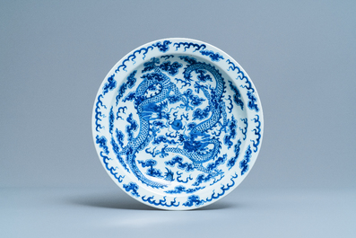 A Chinese blue and white 'dragon' dish and a famille rose figure of Buddha, 19th C.