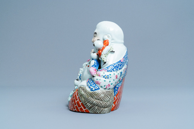 A Chinese blue and white 'dragon' dish and a famille rose figure of Buddha, 19th C.