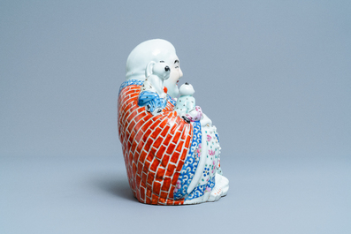 A Chinese blue and white 'dragon' dish and a famille rose figure of Buddha, 19th C.