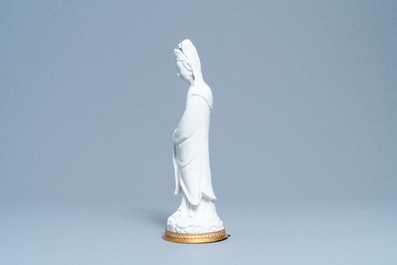 A Chinese blanc de Chine figure of Guanyin on a gilt bronze base, 18/19th C.