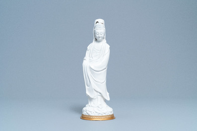 A Chinese blanc de Chine figure of Guanyin on a gilt bronze base, 18/19th C.