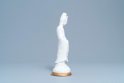 A Chinese blanc de Chine figure of Guanyin on a gilt bronze base, 18/19th C.