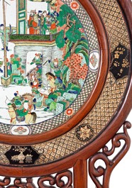 A massive Chinese carved wooden screen with a round famille verte plaque and polychrome lacquer, 19th C.