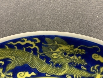 Un plat en porcelaine de Chine en bleu et jaune &agrave; d&eacute;cor d'un dragon, marque et &eacute;poque de Qianlong