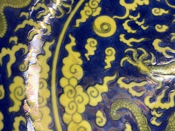 Un plat en porcelaine de Chine en bleu et jaune &agrave; d&eacute;cor d'un dragon, marque et &eacute;poque de Qianlong