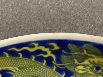 Un plat en porcelaine de Chine en bleu et jaune &agrave; d&eacute;cor d'un dragon, marque et &eacute;poque de Qianlong