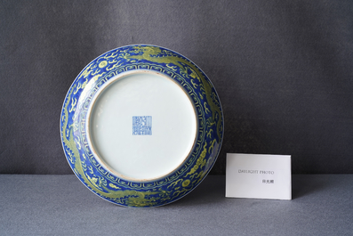 Un plat en porcelaine de Chine en bleu et jaune &agrave; d&eacute;cor d'un dragon, marque et &eacute;poque de Qianlong
