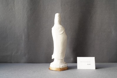 A Chinese blanc de Chine figure of Guanyin on a gilt bronze base, 18/19th C.