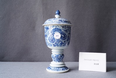 Een Chinese blauw-witte dekselbeker met floraal decor, Kangxi