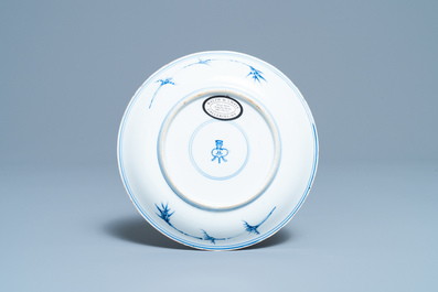 A Chinese blue, white and copper red saucer dish with floral design, Kangxi