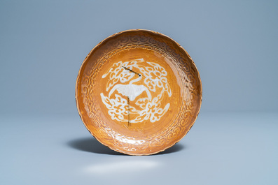 A rare Chinese slip-decorated brown-ground Swatow 'crane' plate, Ming