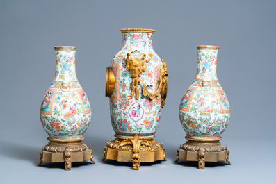 A Chinese gilt bronze-mounted three-piece Canton famille rose clock garniture, 19th C.