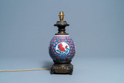 A Chinese blue, white and copper red gilt bronze lamp-mounted vase, 19th C.