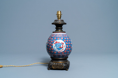A Chinese blue, white and copper red gilt bronze lamp-mounted vase, 19th C.