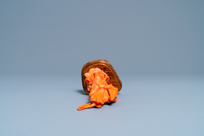 A Chinese carved red coral figure of a warrior holding a flag, 19/20th C.