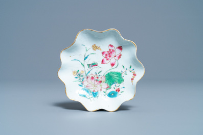 A Chinese famille rose 'lotus' cup and saucer with applied design, Yongzheng