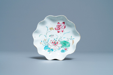 Een Chinese famille rose lotusvormige kop en schotel met reli&euml;fdecor, Yongzheng