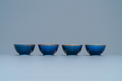Four Chinese gilt-decorated blue-ground cups and saucers with fine landscapes, Qianlong