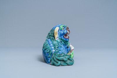 A Chinese porcelain 'Buddhist lion and cub' group on carved wooden stand, 19th C.