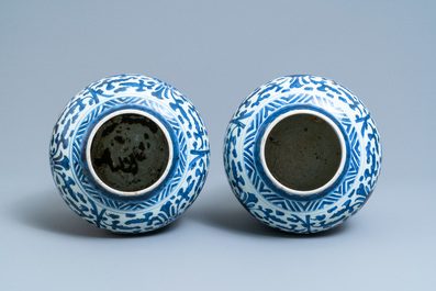 A pair of Chinese blue and white 'lotus scroll' vases and covers, Kangxi