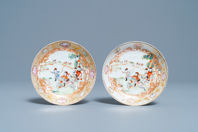 A pair of Chinese gilded famille rose 'Mongolian hunt' cups and saucers, Qianlong