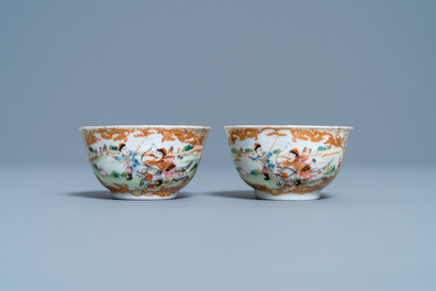A pair of Chinese gilded famille rose 'Mongolian hunt' cups and saucers, Qianlong