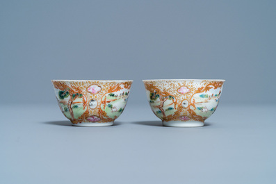 A pair of Chinese gilded famille rose 'Mongolian hunt' cups and saucers, Qianlong