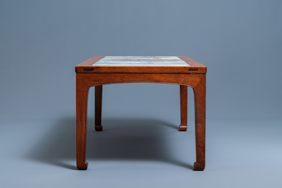 A Chinese wooden table with three qianjiang cai plaques, 19/20th C.