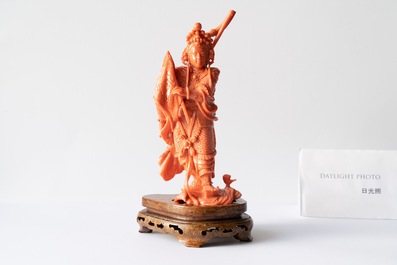 A Chinese carved red coral figure of a warrior holding a flag, 19/20th C.