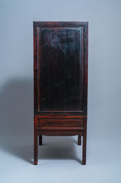 A Chinese hongmu cupboard with a blue and white 'Buddhist lions' plaque, 19th C.