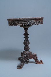 A Chinese carved wooden table with a large Canton famille verte plaque, 19th C.