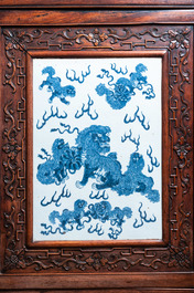 A Chinese hongmu cupboard with a blue and white 'Buddhist lions' plaque, 19th C.