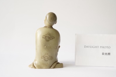 A Chinese Shoushan soapstone figure of a seated man, 18/19th C.