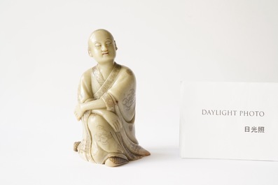 A Chinese Shoushan soapstone figure of a seated man, 18/19th C.